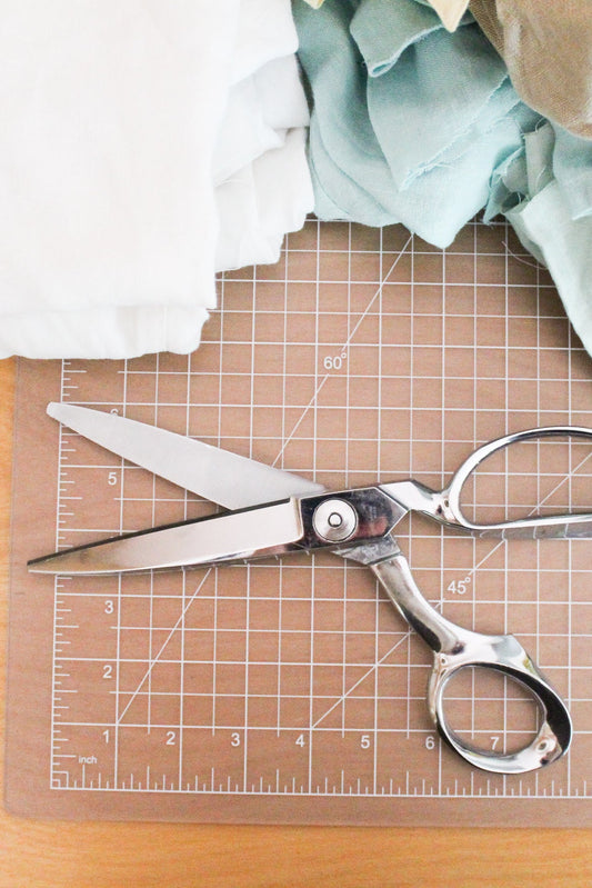 Scissors on a cutting mat with fabric in the background